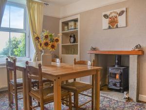 a dining room with a table and a wood stove at Bondcroft Farm Cottage in Embsay