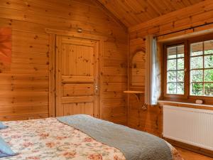 a bedroom with a bed in a wooden room at Bluebell -Uk48309 in Staintondale