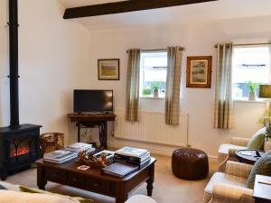 a living room with a table and a fireplace at The Lodge in Dyserth