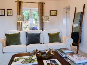 a living room with a white couch and a table at The Lodge in Dyserth