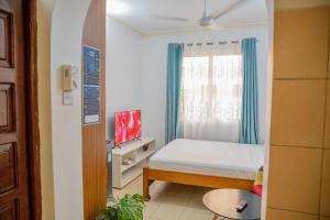 a small bedroom with a bed and a window at Serene Apartments - studio 001 in Mombasa