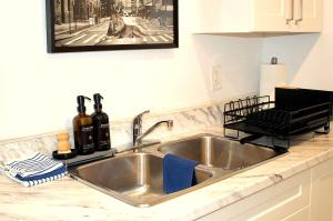 Cozy Bachelor Suite with Kitchenette - Near Downtown في سودبيري: طاولة مطبخ مع حوض في مطبخ +30 صورة