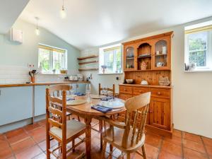 a kitchen with a wooden table and chairs at Church House Cottage in East Stour