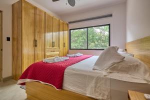 una camera da letto con un letto grande con una coperta rossa di Casa Cretaceous Modern villa 10 min walk to the beach a Sámara Altre 61 foto