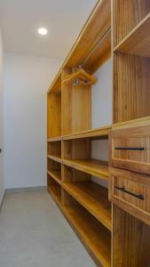 una biblioteca con scaffali di legno in una stanza di Casa Cretaceous Modern villa 10 min walk to the beach a Sámara