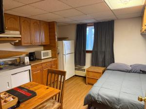 a small kitchen with a bed and a table in a room at Bear Paw Inn 