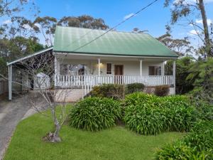 a white house with a green roof at Banksia Mountain Retreat in Katoomba