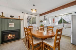 a dining room with a table and a fireplace at Banksia Mountain Retreat in Katoomba