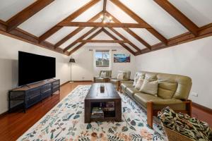 a living room with a couch and a flat screen tv at Banksia Mountain Retreat in Katoomba