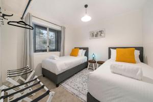 a bedroom with two beds and a window at Banksia Mountain Retreat in Katoomba