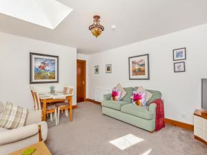 ein Wohnzimmer mit zwei Sofas und einem Tisch in der Unterkunft Fyvie Cottage in Fort William