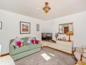 ein Wohnzimmer mit Sofa und Fernseher in der Unterkunft Fyvie Cottage in Fort William