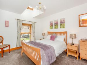 ein Schlafzimmer mit einem Bett und einem Stuhl und einem Fenster in der Unterkunft Fyvie Cottage in Fort William + 10 Fotos