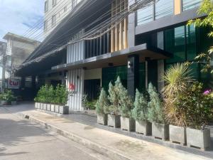 a building with potted plants in front of it at Thana Wisut Hotel in Bangkok