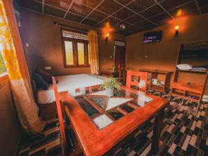 a room with a wooden table and a bed at View Paradise in Ella