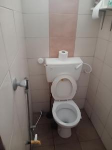a bathroom with a toilet with a roll of toilet paper at Serene Apartments - studio 001 in Mombasa