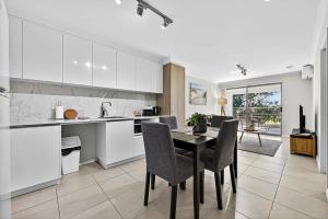 a kitchen and dining room with a table and chairs at Stylish Rockingham Getaway 2BR Coastal Apartment in Rockingham