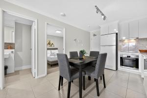 a kitchen and dining room with a table and chairs at Stylish Rockingham Getaway 2BR Coastal Apartment in Rockingham