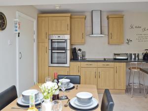 a kitchen with wooden cabinets and a table with dishes on it at Mill View House in Scarborough