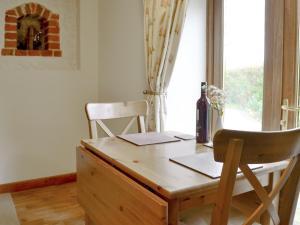 a wooden desk with a chair next to a window at Hay Loft -23894 in Aylmerton