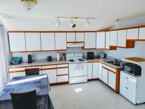 a kitchen with white cabinets and a stove top oven at Alert Bay, Spacious Executive Suite with Panoramic Ocean Views in Alert Bay
