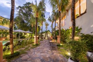 a courtyard with palm trees and a table and chairs at Anam Tang New Rooms & Cafe near Seminyak in Seminyak