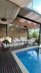 a swimming pool with chairs and umbrellas on a building at Aimo Villa in Ciburial