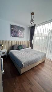 a bedroom with a bed and a large window at Aimo Villa in Ciburial