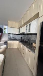 a kitchen with white cabinets and black counter tops at Aimo Villa in Ciburial +3 photos
