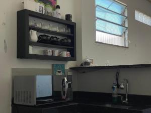 a kitchen with a counter top with a microwave at Apartamento próximo ao Hangar - COP 30 in Belém +3 photos