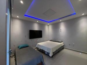 a bedroom with a bed and a blue light at Apartamento próximo ao Hangar - COP 30 in Belém
