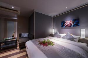 WadaにあるHotelTSUBAKI柏のベッドルーム1室(大型ベッド1台、フラワーアレンジメント付)