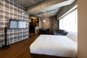 a bedroom with a large bed and a tv at Amp Flat Arc Bliss 4 in Chikushino