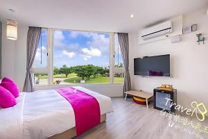 Un dormitorio con una cama y una ventana grande. en 墾丁卿卿文旅, en Hengchun