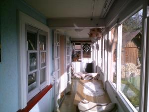 eine leere Veranda mit einer Bank vor den Fenstern in der Unterkunft Appartement in Innerlehen mit Terrasse, Grill und Garten in Bernau im Schwarzwald