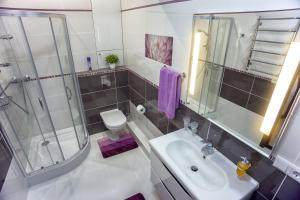 a bathroom with a sink and a shower and a toilet at Golfstrim in Odesa