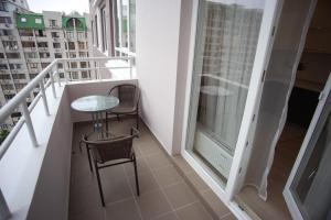 a balcony with a table and two chairs and a window at Golfstrim in Odesa