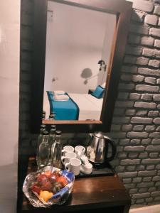 a table with a bowl of fruit and a mirror at Blue Pillars Kandy in Kandy
