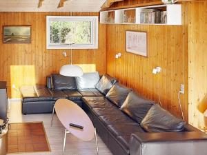 ein Wohnzimmer mit einer Ledercouch und einem Tisch in der Unterkunft 6 person holiday home in Nørre Nebel-By Traum in Lønne Hede