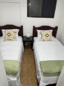 two beds sitting next to each other in a bedroom at Cabaña Villa Morena in Arroyo Hondo