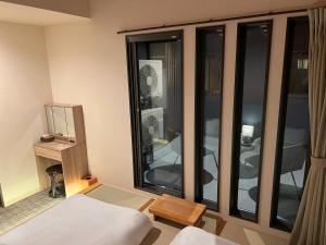 a room with a bed and a large window at おおさか城北 宿福 in Osaka