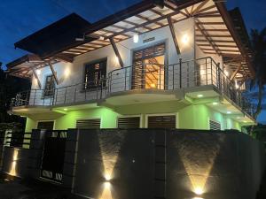a large white house with a balcony at night at King Royal - Tangalle in Tangalle