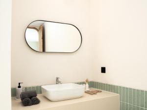 a bathroom with a sink and a mirror on the wall at Aquae Villas - Palma - Luxury and Cozy 1bdr Villa - Kuta Lombok in Kuta Lombok