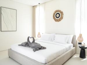a bedroom with a bed with a stuffed animal on it at Aquae Villas - Palma - Luxury and Cozy 1bdr Villa - Kuta Lombok in Kuta Lombok