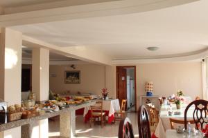 a dining room with a table with food on it at Hotel Central in Vitória da Conquista