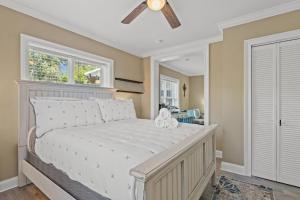 a bedroom with a white bed with a ceiling fan at Historic Downtown Waterfront Access Near Beach in Panama City Beach