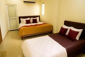 a hotel room with two beds and a door at Hotel Kalaptaru in Nainital
