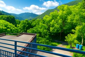 a balcony with a view of trees and mountains at Hotel Kalaptaru in Nainital