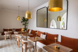 a restaurant with tables and chairs and a mirror at Riad Dar Melia in Marrakesh