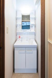 a white bathroom with a sink and a mirror at Amp Flat Arc Bliss 3 in Chikushino +36 photos